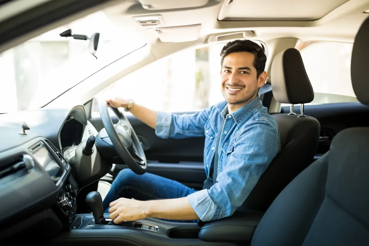 Conductor latino sonriendo en su carro